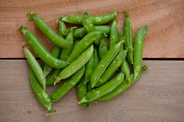 Fresh green peas on wooden background