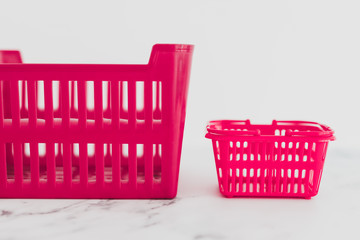 big vs small budget concept with different size shopping baskets next to each other