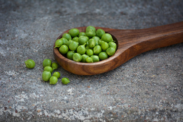 Fresh green peas in the wooden spoon
