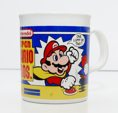 london, england, 05/05/2018 a super mario official nintendo 1990s super mario bros mug coffee cup and bowser toy isolated on a white background. official merchandise.