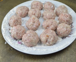  meatballs sprinkled with flour lie on a dish
