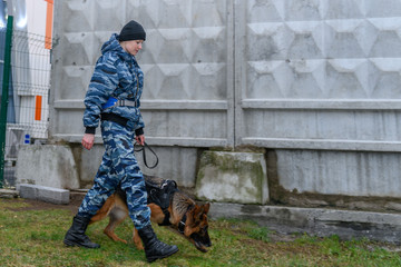 Female police officers with a trained dog. German shepherd police dog.