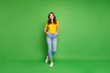 Full length body size view of her she nice attractive lovely cheerful cheery content wavy-haired girl holding hands in pockets isolated over bright vivid shine vibrant green color background