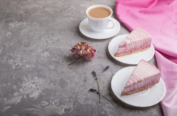 Homemade pink cheesecake with cup of coffee on a gray concrete background. side view, copy space.