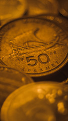 A pile of different gold coins on the table, focus on the Greek coin Drachma.