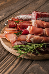 delicious meat platter served with rosemary on wooden board