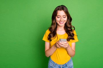 Portrait of her she nice attractive lovely pretty charming cute cheerful cheery wavy-haired girl writing sms message chatting online isolated on bright vivid shine vibrant green color background