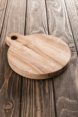 Fototapeta na wymiar brown empty cutting board on wooden table