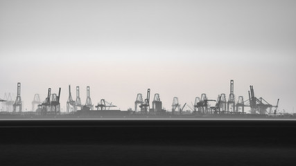 Commercial port silhouette in the horizon with cranes, long exposure