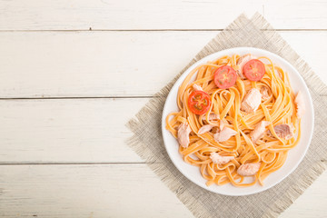 Semolina pasta with salmon on a white wooden background. Top view, copy space.