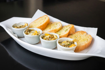 Baked baby clams with butter, onions, parsley served with garlic and butter french bread.
