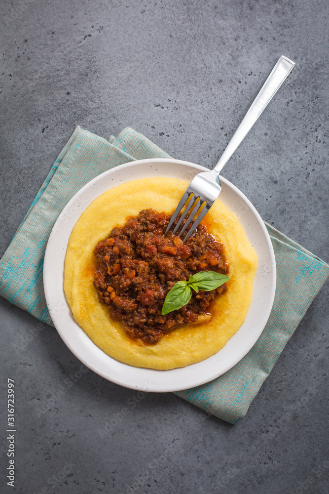 Poster polenta (boiled cornmeal) with meat-based sauce - ragù alla bolognese.