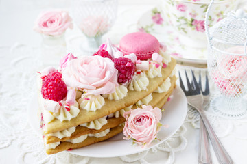 Fototapeta na wymiar Romantic Valentine's Day breakfast. Sweet dessert - a piece of cake with macaroons and roses.