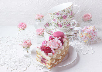 Romantic Valentine's Day breakfast. Sweet dessert - a piece of cake with macaroons and roses.