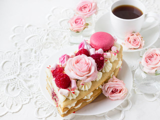 Romantic Valentine's Day breakfast. Sweet dessert - a piece of cake with macaroons and roses.