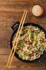 Fried veal, with rice, Chinese cabbage and mushrooms. Sprinkled with sesame and soy sauce. - obrazy, fototapety, plakaty