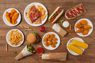 Mix of fast food, street dishes. Background with copy space. Top view. Natural wooden background.