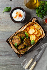 Vegetarian spinach and broccoli meatballs, served with yogurt dip and toasted potatoes. Top view.