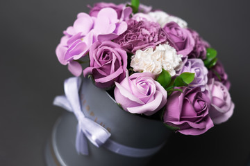 Flowers in bloom: Bouquet of lilac and white roses in a gray round box on a gray background.