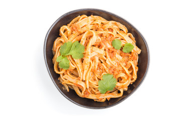 Semolina pasta with tomato pesto sauce, orange and herbs isolated on white background. Top view, close up.