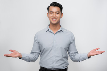 Attractive young Asian man smiling and welcoming heartily with arms open - obrazy, fototapety, plakaty
