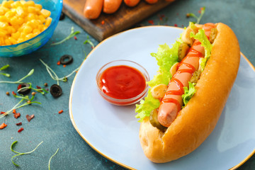 Plate with tasty hot dog on table