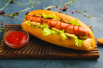 Tasty hot dog and sauce on table