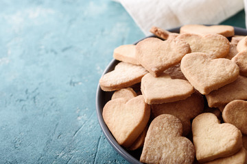 closeup plate of homemade cookies with hearts on blue background