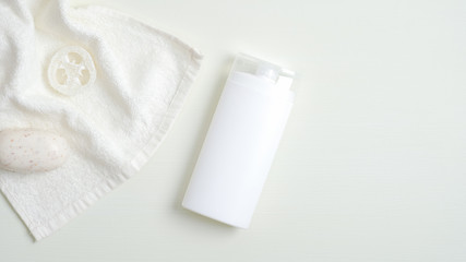 Cosmetics SPA branding mockup, flat lay minimalist style. Clear shampoo bottle, bath towel, natural organic soap and luffa sponge. Top view, flat lay