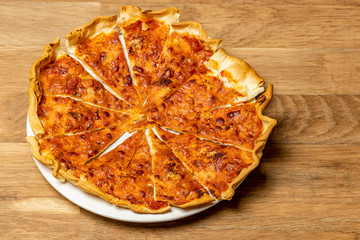 Pizza, mozzarella cheese and tomato, on a wooden background.