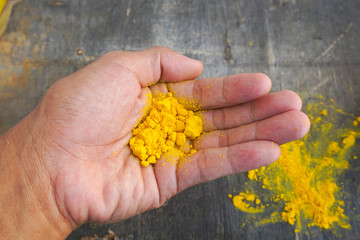 close up shot turmeric powder at hand 