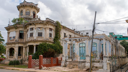 Fototapeta na wymiar dilapidated building in havana with a yellow convertible classic car, cuba