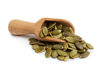 Raw shelled pumpkin seeds in wooden scoop isolated on white background