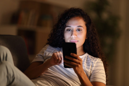 Woman in the night at home using smart phone