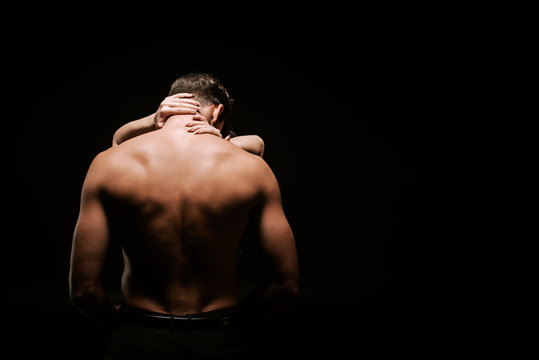 back view of sexy man hugging with woman isolated on black