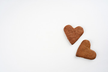 Two heart shape gingerbread cookies on white background. Valentine, love, invitation, recipe, card concept. Top view, flat lay, copy space