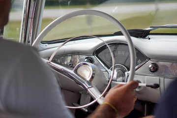 inside a cuban classic car with the driver and the steering wheel, cuba
