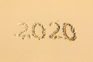 Summer beach holiday 2020 season golden sand - old year - decade - new season lettering on the beach - Numbers 2020 year on the sea shore, message handwritten New Years concept copy empty space