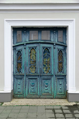 Fototapeta na wymiar Retro vintage wooden door with metal and wood carvings on the european public building exterior.