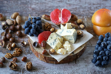 Mix of cheeses, nuts and fruits. Healthy snack. Appetizer to wine. Selective focus.