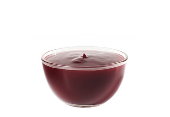 Berry sauce in a glass bowl close-up on a white background