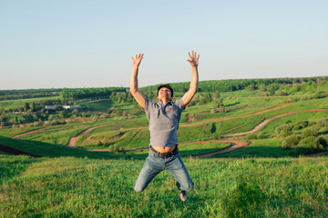 Fototapeta na wymiar A man in jeans and a T-shirt in a jump. The male is happy and free in nature