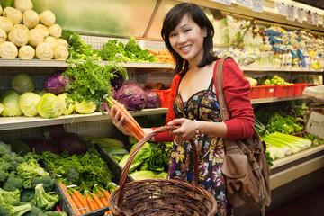 Portrait of young woman shopping for vegetables in farmer's market