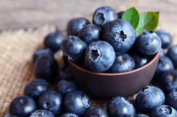 Freshly picked organic blueberries in a brown bowl on wooden background.Blueberry. Bilberries. Healthy eating,vegan food or diet concept with copy space.Selective focus.