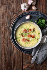 Caldo Verde soup made of savoy cabbage, pureed potatoes, onion, garlic and fried sausage slices in a ceramic bowl