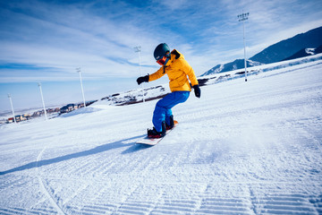 One snowboarder snowboarding in winter mountains