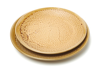 Empty earthenware plate on white background