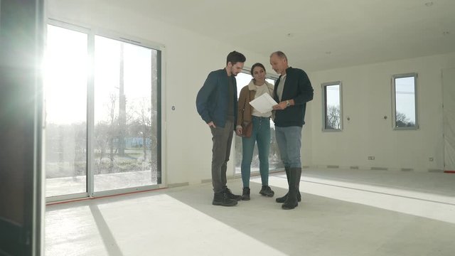Young couple visiting house under construction