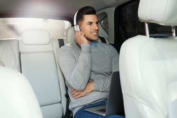 Fototapeta na wymiar Handsome man listening to audiobook in car