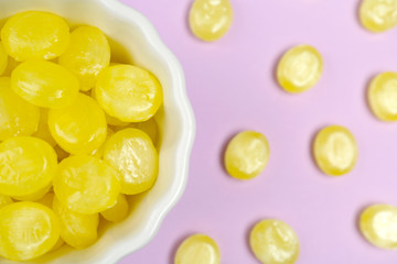 Flat lay composition with tasty lemon drops on violet background